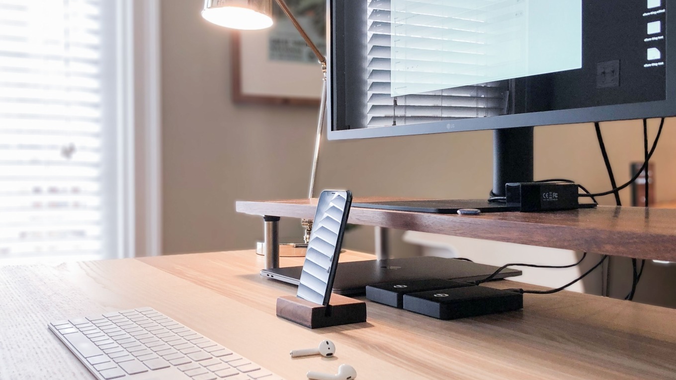 Phone propped up in front of a desktop computer